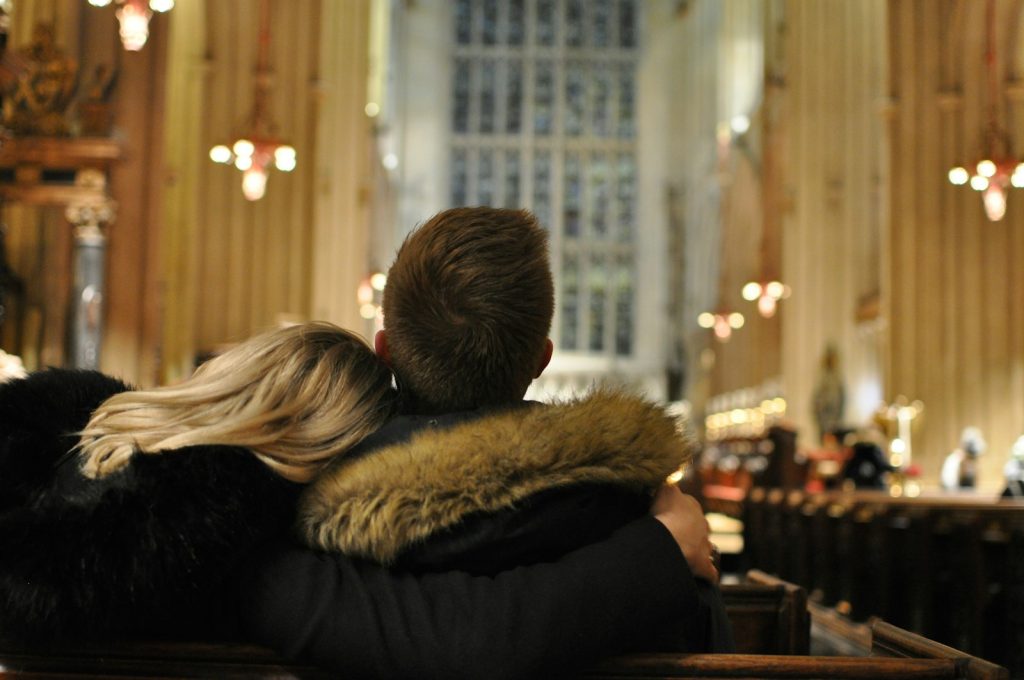 a man and woman sitting in a church